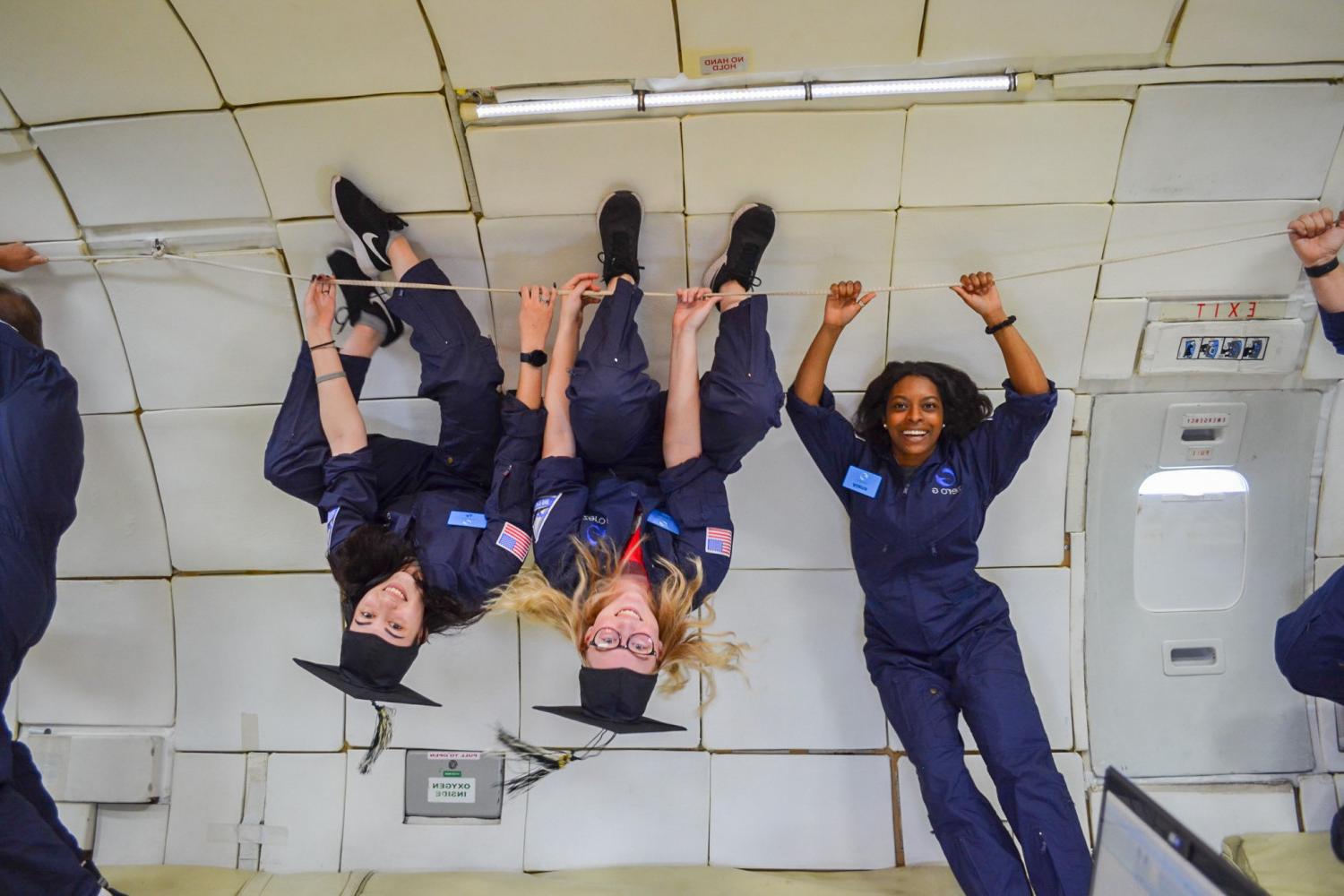 Students on board NASA's zero gravity aircraft take a break from conducting research to celebrate their graduation.